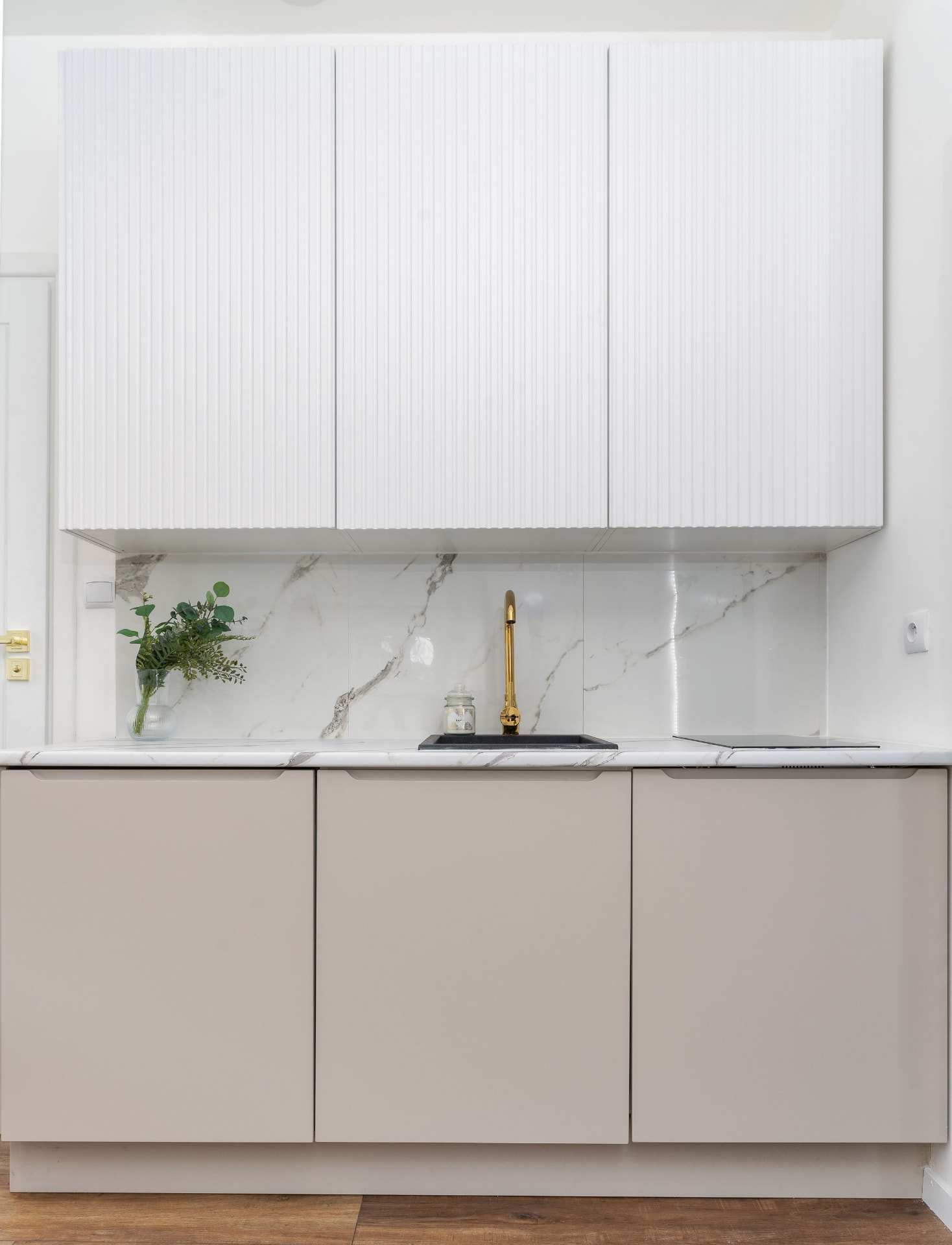 Fluted white upper cabinets over greige handleless base cabinets