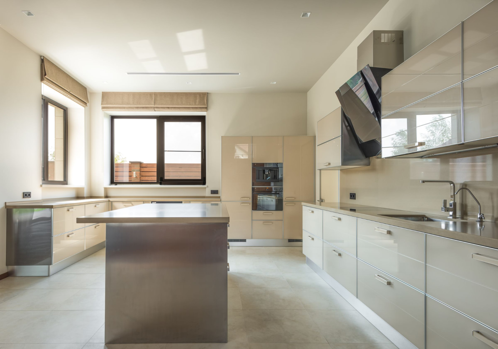 Cream gloss frameless kitchen with a long island and stainless appliances